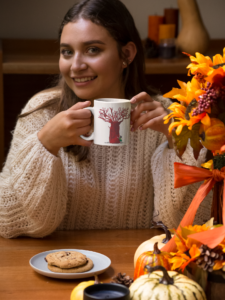 mockup-of-a-woman-holding-an-11-oz-coffee-mug-at-a-dinner-table-29137 (1)